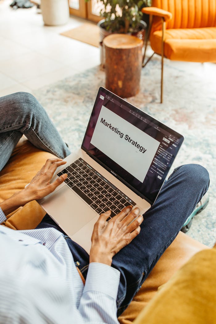 Close-up of a person working on a laptop focused on marketing strategy, indicative of a collaborative workspace.